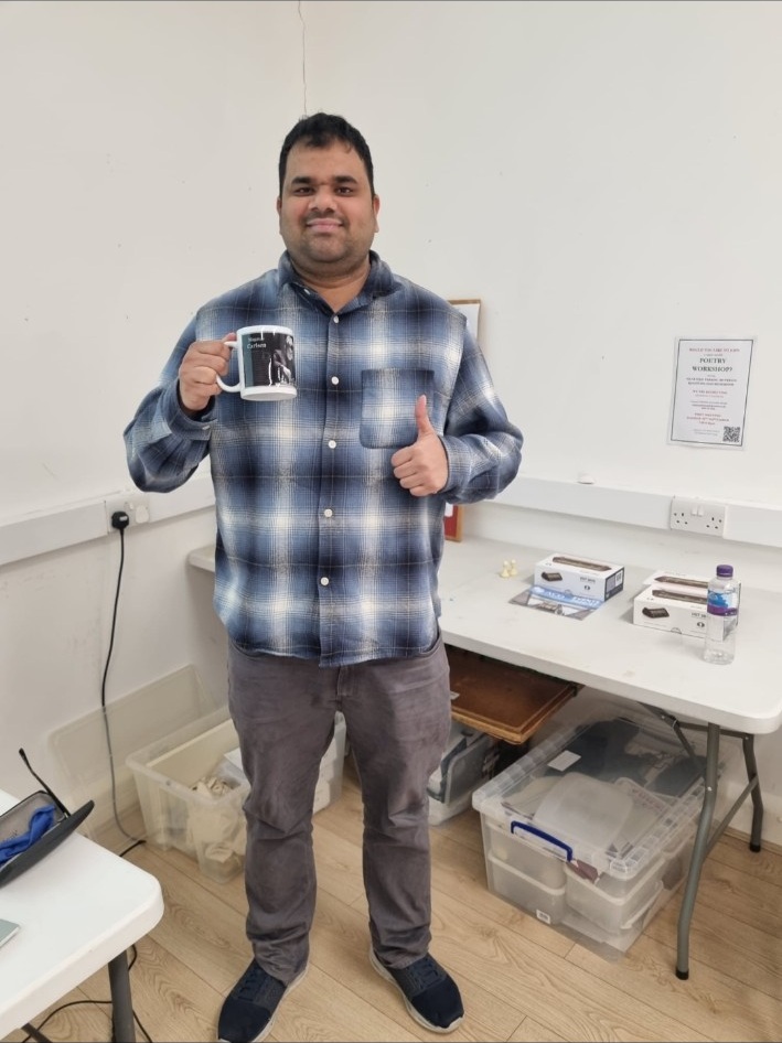 Rapid Championship winner Kligan Braganca holding a mug and giving a thumbs-up at Staines Chess Club.